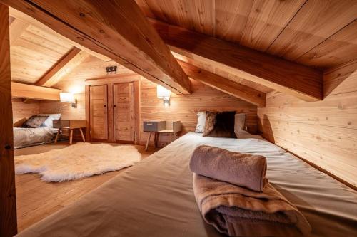 1 dormitorio en una cabaña de madera con 1 cama grande en Chalet Charme & SPA - Serre Chevalier 1500, en Le Monêtier-les-Bains
