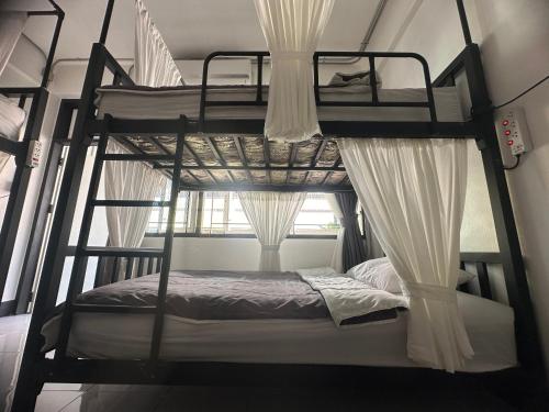 a bedroom with two bunk beds and a window at Backpack Hostel in Chiang Rai
