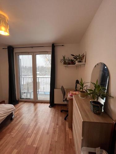 Pokój z łóżkiem i dużymi przesuwnymi szklanymi drzwiami w obiekcie Bright Rooms w Krakowie