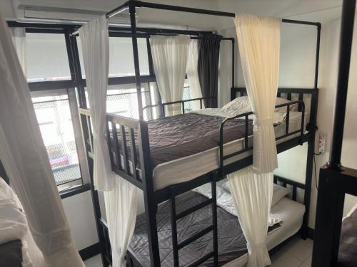 a bedroom with two bunk beds with curtains at Backpack Hostel in Chiang Rai