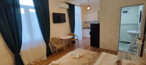 a room with a bed and a table and a kitchen at Guest House Alazani Valley in Sighnaghi