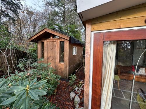 een houten bijgebouw naast een huis bij B&B de Hinne in Holten