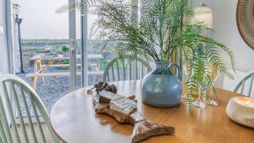 a wooden table with a vase and a wooden figurine on it at Ty Cwyfan in Aberffraw