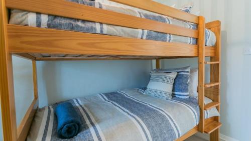 two bunk beds in a room with a bed at Ty Cwyfan in Aberffraw