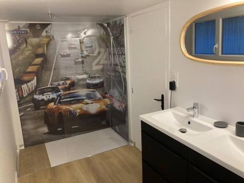 une salle de bains avec une peinture murale représentant une voiture. dans l'établissement maison 4 chambres aux portes du circuit, au Mans