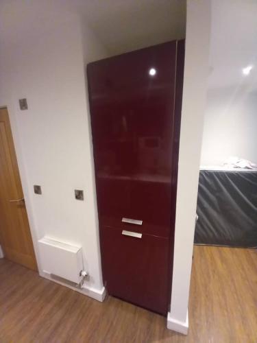 a large brown cabinet in a room with a bed at Deve home in Manchester