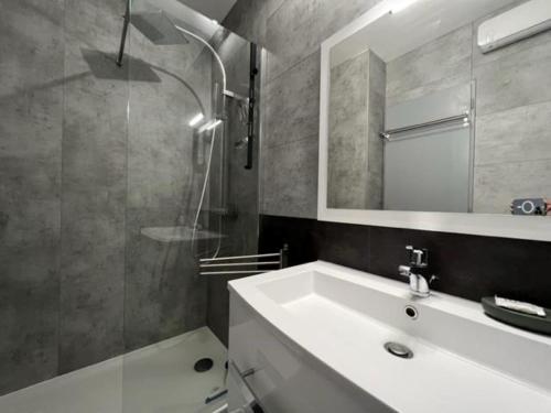 y baño con lavabo blanco y espejo. en F2 à Collioure avec piscine et tennis, en Collioure
