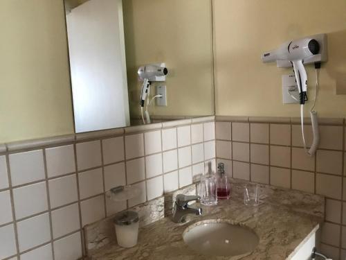 a bathroom with a sink and a mirror at Delicioso flat em área nobre in Sao Paulo