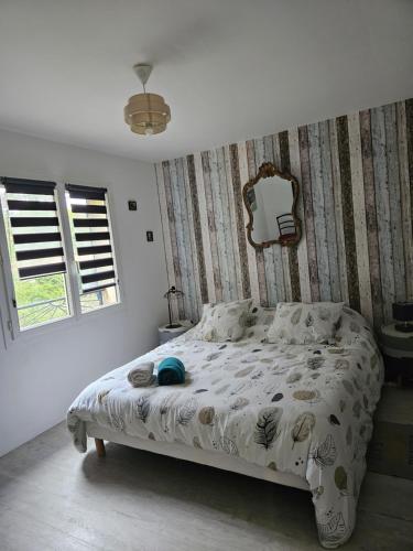 a bedroom with a bed with a white comforter at au coeur des vignes in Noaillan