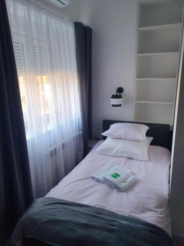 a small bed with two pillows and a window at Comfort Stay, EV, Parking in Bolesławiec