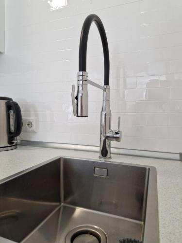 a kitchen sink with a faucet on a counter at Magnolia: Moderne, voll möblierte Wohnung in Bietigheim-Bissingen