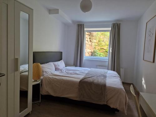 1 dormitorio con cama y ventana en Magnolia: Moderne, voll möblierte Wohnung, en Bietigheim-Bissingen