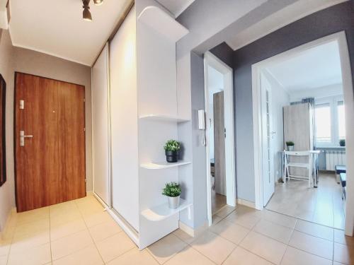 a hallway with white walls and a wooden door at Dobre Sny na Konopnej in Bydgoszcz