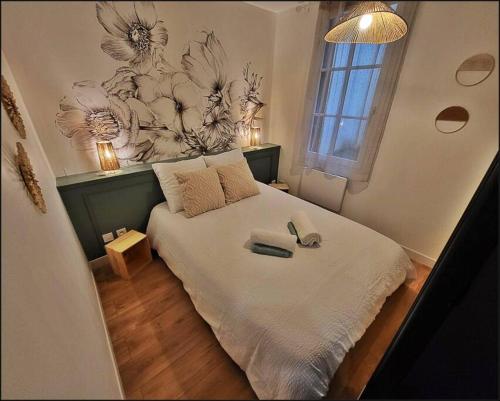 une chambre avec un lit avec deux chaussures dessus dans l'établissement Le Berbiz Dijon centre ville, à Dijon