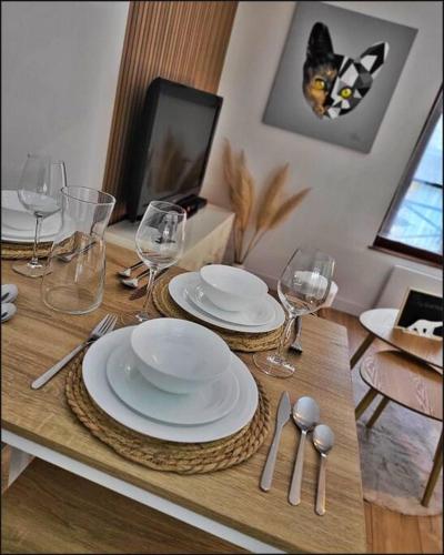 une table avec des assiettes et des verres à vin dessus dans l'établissement Le Berbiz Dijon centre ville, à Dijon