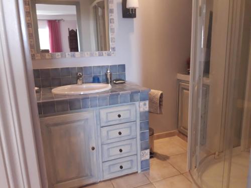 une salle de bain avec un lavabo et un miroir dans l'établissement Grand gîte dominant le golfe d'Ajaccio, à Bastelicaccia