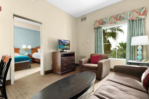 sala de estar con dormitorio con cama y sofá en Family Condo-2 rooms Top floor pool view -Theme parks Free Shuttle, en Orlando