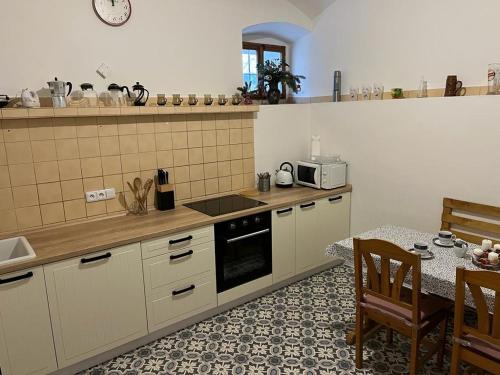 cocina con mesa y fogones horno superior en Usedlost Pod lipou, en Malá Morava
