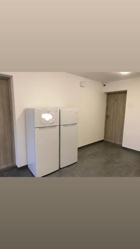 an empty room with a refrigerator and two doors at Roomflacja in Wisła