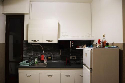 佛羅倫斯的住宿－Florence Rooms Novella，厨房配有白色橱柜、水槽和冰箱。