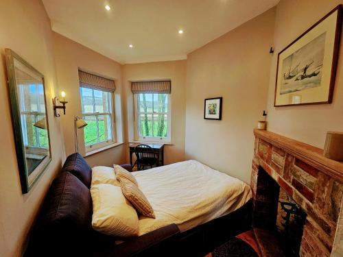 a bedroom with a bed and a fireplace at The Lookout: Cosy Compact Cottage in Totland