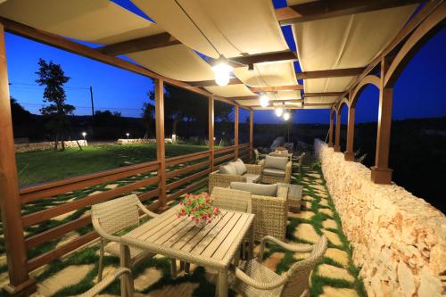 a patio with a table and chairs and lights at La Valle delle Rose in Massafra