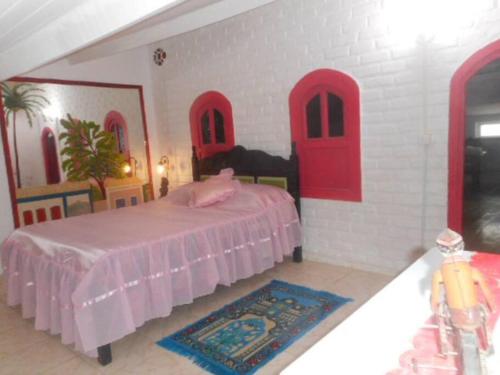 um quarto com uma cama com portas vermelhas e um tapete em Lindo Apartamento: centro, terraço com linda vista mar e tudo perto! em Porto Seguro