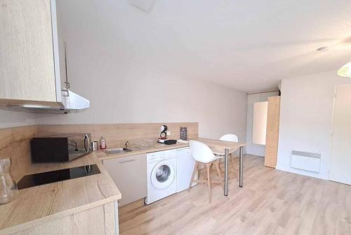 une cuisine avec une machine à laver et une table dans l'établissement Studio - Centre Ville - Terrasse, à Agen