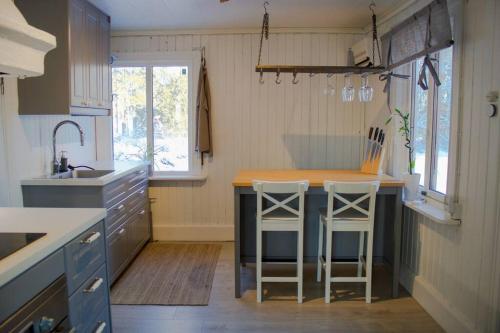 una cocina con una isla con dos taburetes. en Bagarstugan en Falun