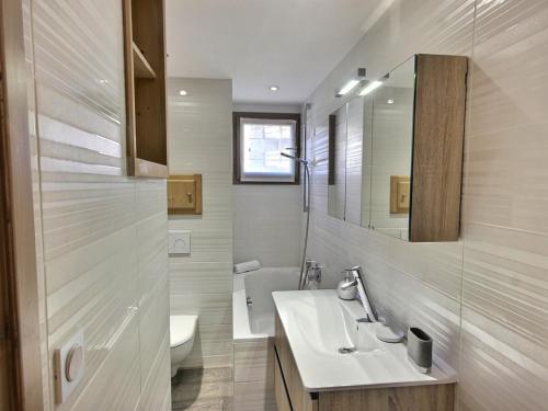 a bathroom with a sink and a toilet and a mirror at Bel appartement cosy de 50m² pour 4 pers, pied des pistes Méribel Mottaret avec terrasse et parking - FR-1-411-913 in Les Allues