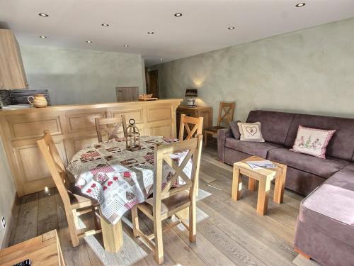 un salon avec une table et un canapé dans l'établissement Bel appartement cosy de 50m² pour 4 pers, pied des pistes Méribel Mottaret avec terrasse et parking - FR-1-411-913, à Les Allues