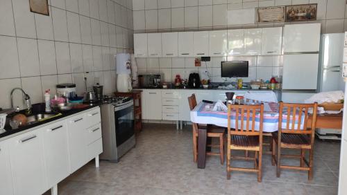 een keuken met een tafel en stoelen. bij Casa Da Ana in Caraguatatuba