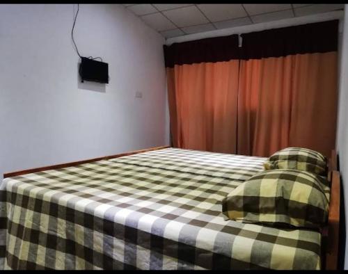 um quarto com uma cama com um cobertor xadrez em Octandra Lodge em Suriyawewa