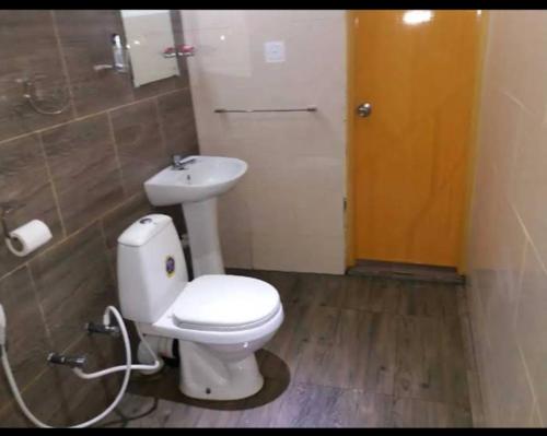 a bathroom with a white toilet and a sink at Octandra Lodge in Suriyawewa