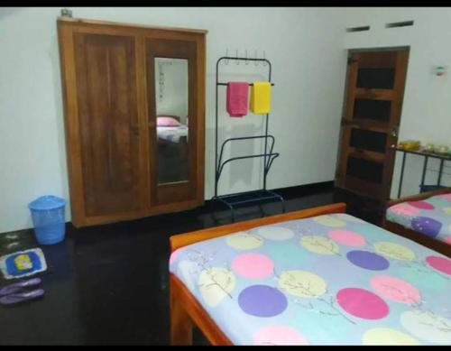 Schlafzimmer mit einem Bett, einer Kommode und einem Spiegel in der Unterkunft Octandra Lodge in Suriyawewa