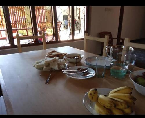 einen Tisch mit Teller mit Lebensmitteln und Bananen drauf in der Unterkunft Octandra Lodge in Suriyawewa