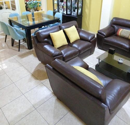 a living room with a leather couch and a table at HOTEL G&EMP Rador BARRANCA in Barranca
