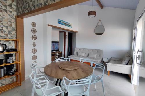 a living room with a wooden table and white chairs at Casa Silandia, tu casa en Búzios in Búzios