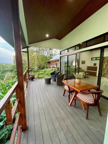 a wooden deck with a wooden table and chairs at Casa Donna Rosa B&B in Nuevo Arenal