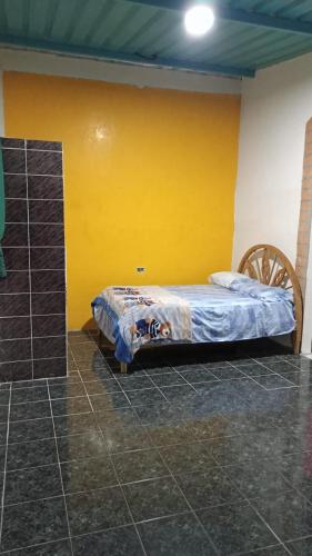 a bedroom with a bed and a yellow wall at Vacation home Bellavista in Santo Domingo de los Colorados