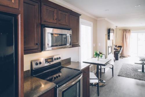 a kitchen with a stove and a microwave at The Great George in Charlottetown