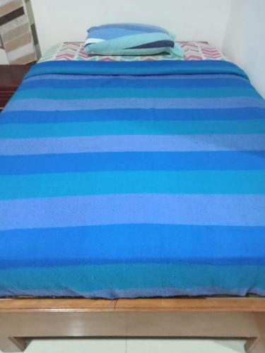 a bed with blue sheets on top of it at Vacation home Bellavista in Santo Domingo de los Colorados
