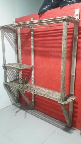 a red wall with two wooden shelves on it at Vacation home Bellavista in Santo Domingo de los Colorados
