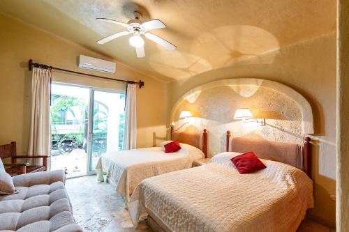 una camera da letto con due letti e un ventilatore a soffitto di Villas Xaguar by PlayaSky a Playa del Carmen