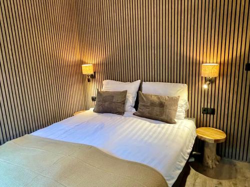 a bedroom with a bed with two pillows on it at Wellness in the Woods - 4p TinyHouse met privé sauna & hottub in Diessen