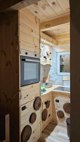 a kitchen in a log cabin with a tv in it at Chalet Wood Magic in Kolašin