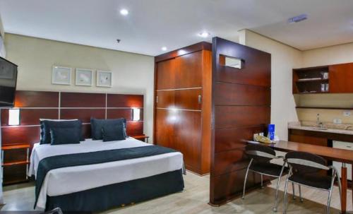 - une chambre avec un lit, un bureau et un lavabo dans l'établissement Delicioso flat em área nobre, à São Paulo