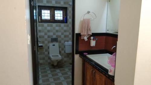a bathroom with a toilet and a sink at Greenland Homestay in Manimala