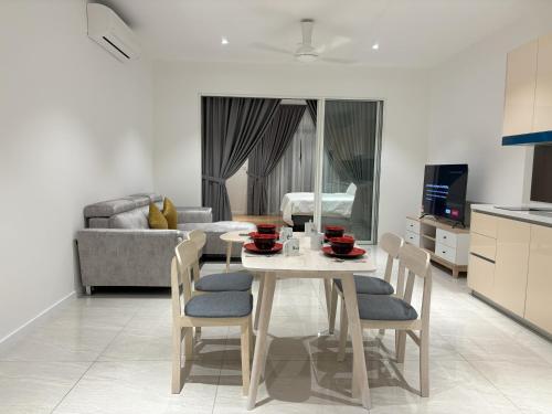 Quill Residence KL by Bamboo Hospitality في كوالالمبور: مطبخ وغرفة معيشة مع طاولة وكراسي