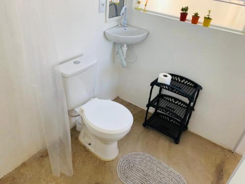 a bathroom with a white toilet and a sink at LUGAR in Penha